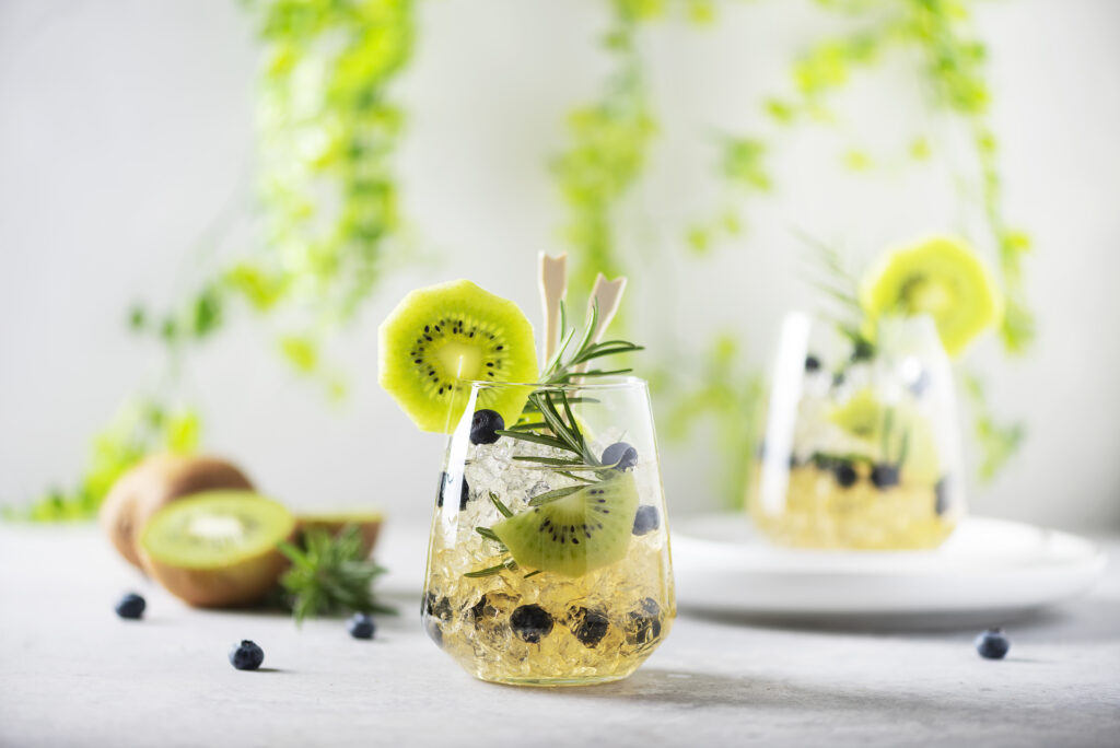 Summer cocktail with kiwi, blueberry, rosemary and ice.